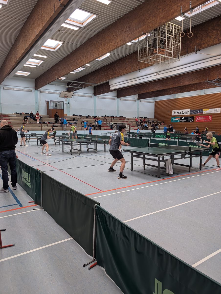 Blick in eine Turnierhalle mit mehreren Tischtennisplatten beim Bezirkspokal.