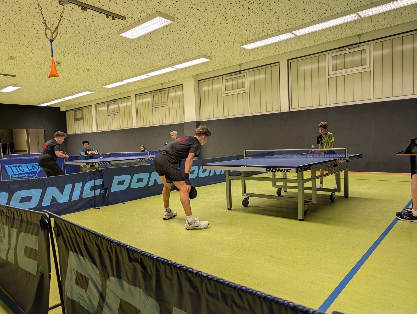 Spieler der zweiten Jugendmannschaft des TTC Landeck an den Platten in der Halle.