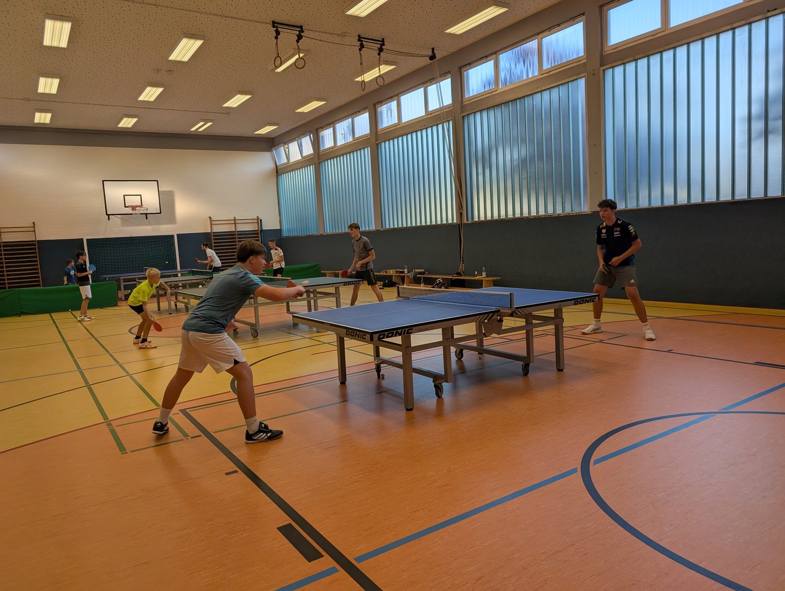 Spieler des TTC Landeck beim Training an mehreren Tischtennisplatten in der Schulturnhalle.
